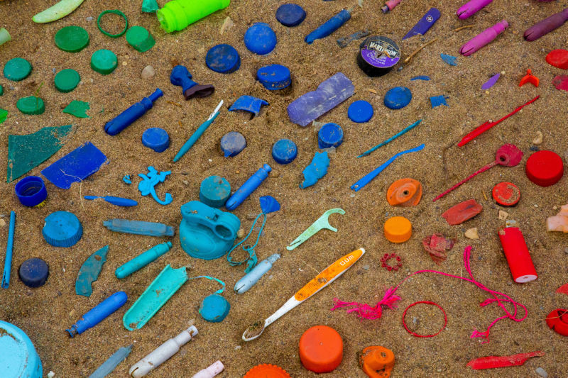 שוחים בפלסטיק: חלקי מוצרי פלסטיק על חוף הים